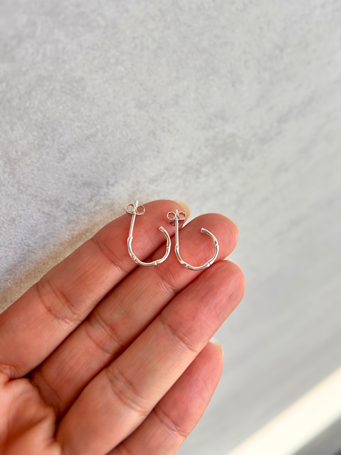 Argollas en plata de ley con textura de bambú y cierre de mariposa. Pequeñas y ligeras, son perfectas para el uso diario. Una joya básica para cualquier ocasión.