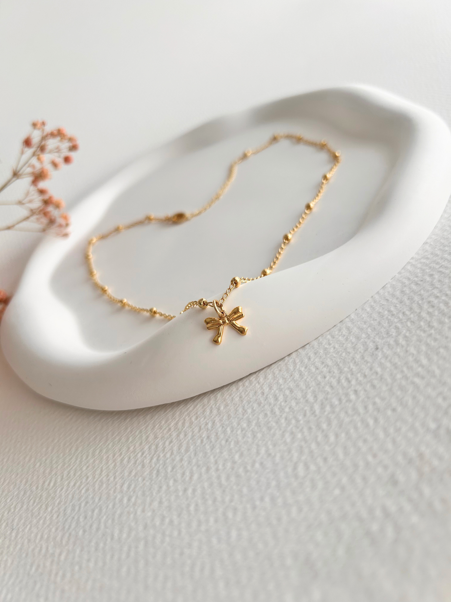 Choker con lazo en oro laminado (gold filled) 18K. Delicado y duradero, con estilo coquette para un toque femenino y juguetón. Collar corto ajustable con dije. Cadena con cuentas, tipo satélite. Regalo romántico para ella, Trópico Jewelry