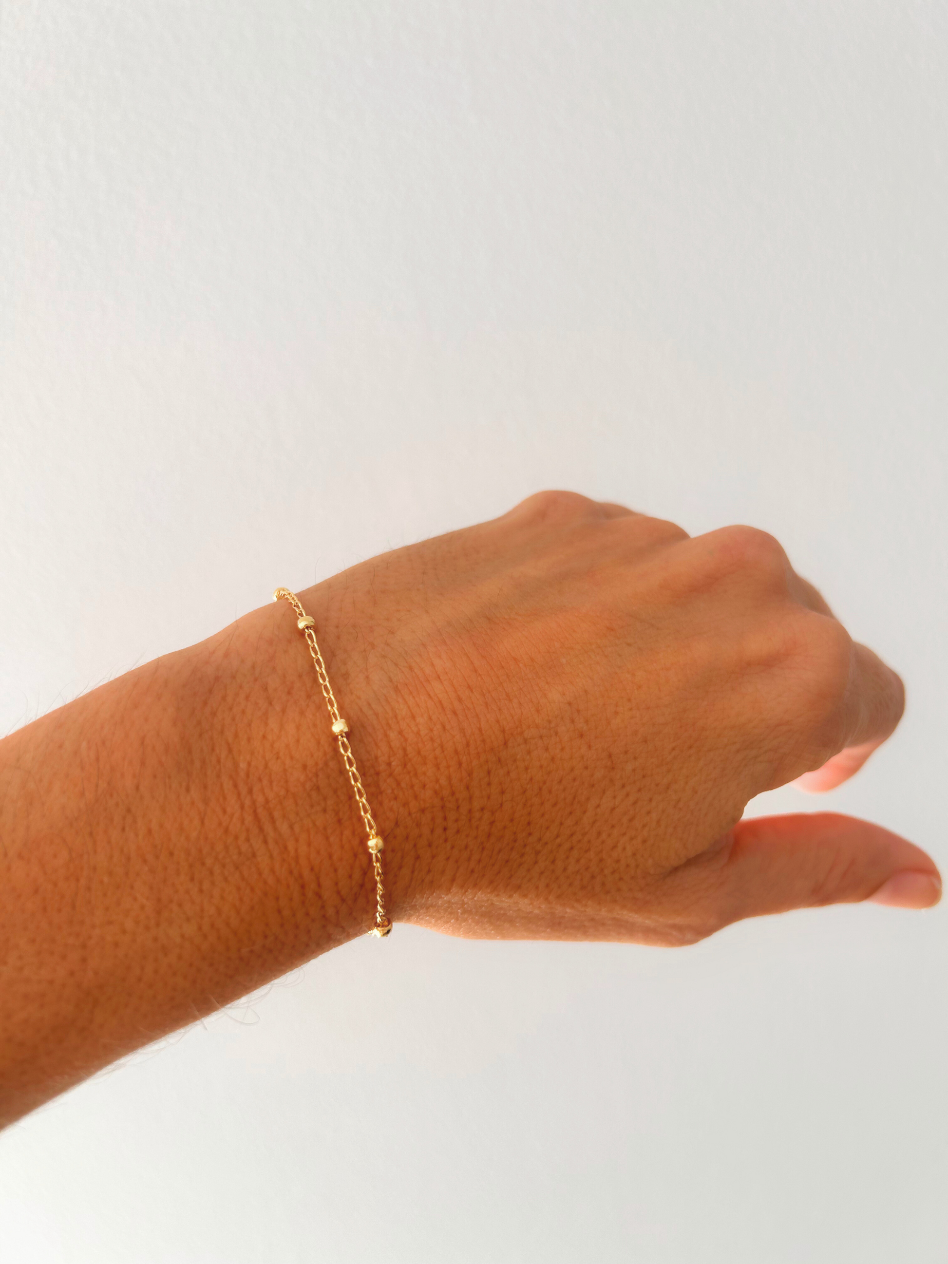 Pulsera satélite con cadena fina y bolitas, en oro laminado 18K (gold filled). Versátil, delicada y atemporal, a la vez que moderna y trendy, es un regalo perfecto. Hecha a mano en España por Trópico Jewelry.