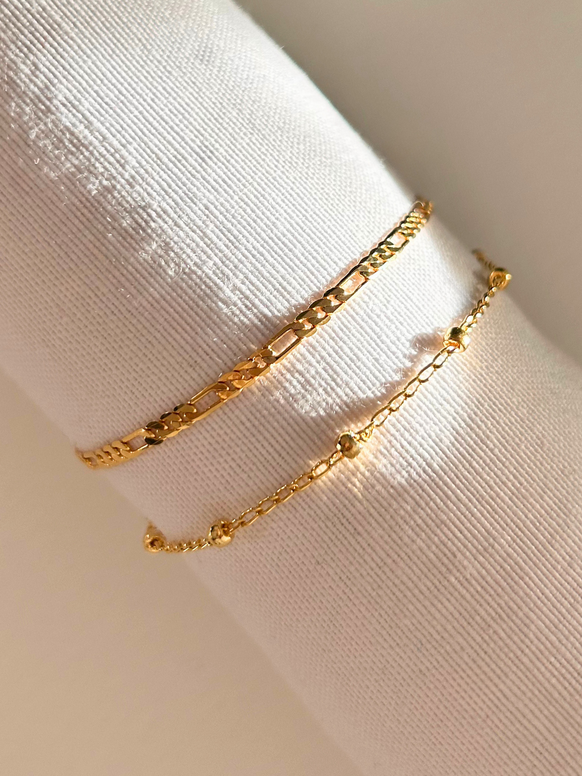 Dúo de Pulseras en oro laminado 18K (gold-filled). Conjunto o set de pulsera fígaro y pulsera satélite. Pulsera duraderas hechas a mano en España por Trópico Jewelry.