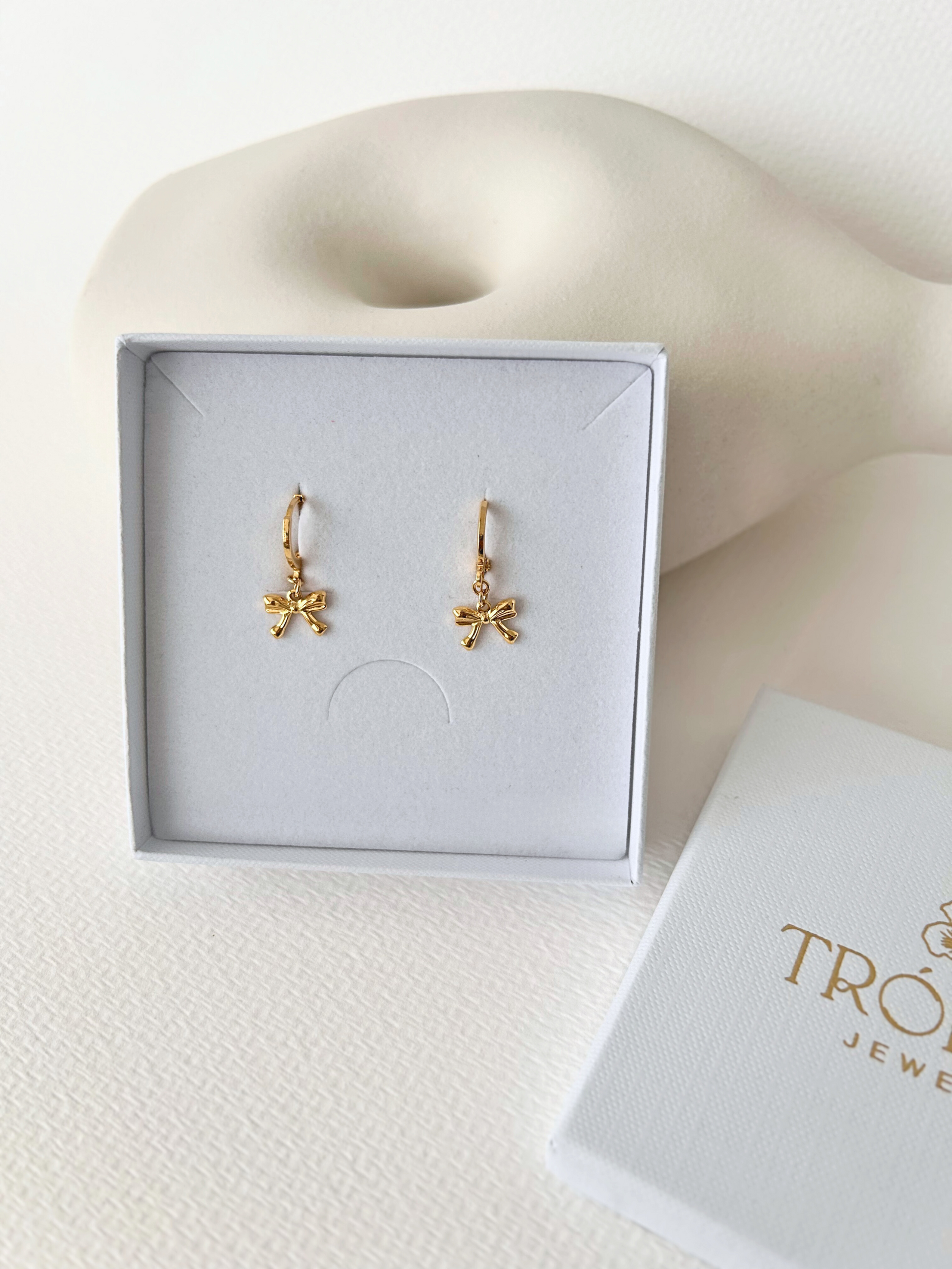 Pendientes de argollas con lazos en oro laminado 18K (gold filled). De estilo coquette, son muy femeninos y favorecedores. Duraderos, resistentes al agua y perfectos para el uso diario. Son ideales como un regalo delicado para mujer. Trópico Jewelry.