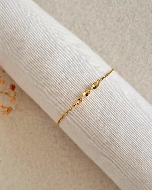 Pulsera delicada con conector geométrico retorcido en forma de remolino, chapada en oro 18K. Regalo minimalista mujer. Trópico Jewelry