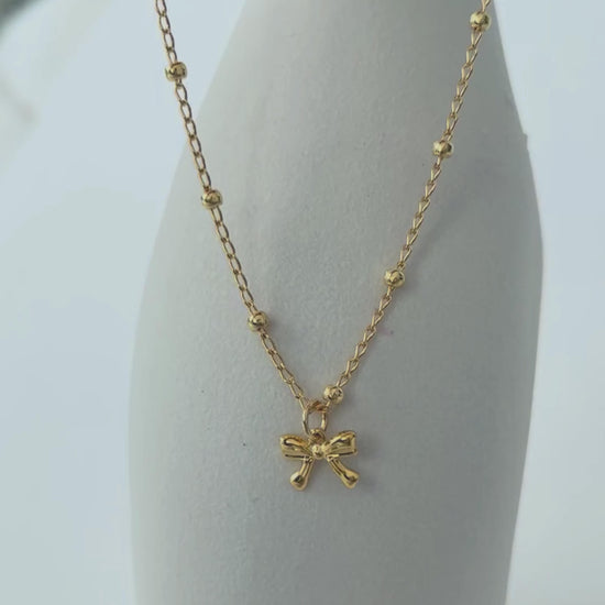 Choker con lazo en oro laminado (gold filled) 18K. Delicado y duradero, con estilo coquette para un toque femenino y juguetón. Collar corto ajustable con dije. Cadena con cuentas, tipo satélite. Regalo romántico para ella, Trópico Jewelry
