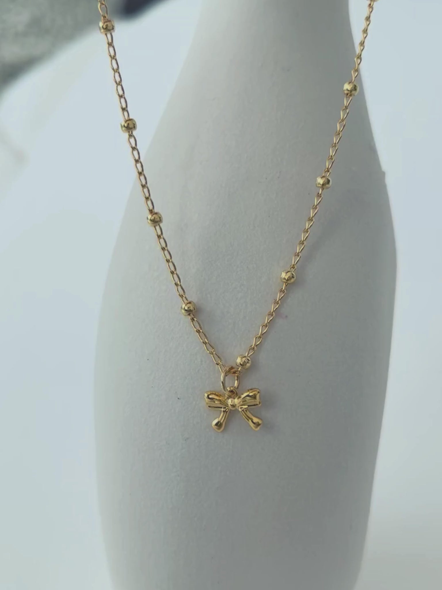 Choker con lazo en oro laminado (gold filled) 18K. Delicado y duradero, con estilo coquette para un toque femenino y juguetón. Collar corto ajustable con dije. Cadena con cuentas, tipo satélite. Regalo romántico para ella, Trópico Jewelry