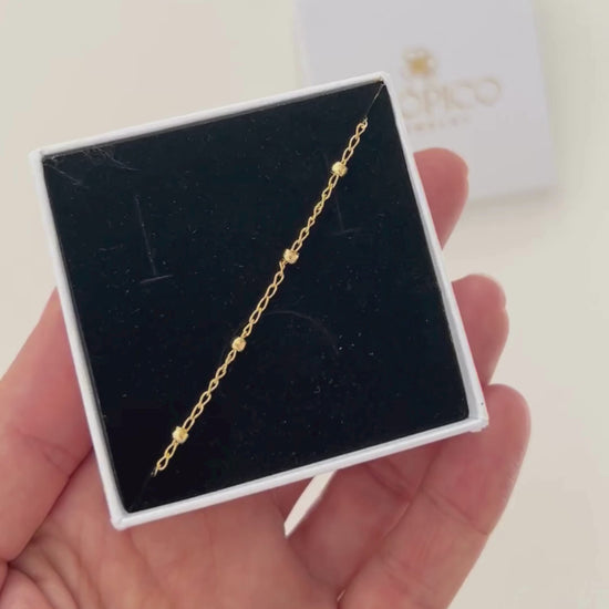 Pulsera satélite con cadena fina y bolitas, en oro laminado 18K (gold filled). Versátil, delicada y atemporal, a la vez que moderna y trendy, es un regalo perfecto. Hecha a mano en España por Trópico Jewelry.