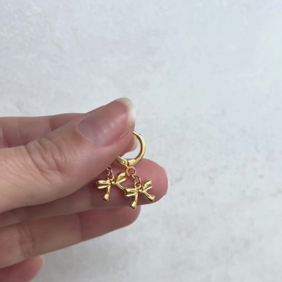 Pendientes de argollas con lazos en oro laminado 18K (gold filled). De estilo coquette, son muy femeninos y favorecedores. Duraderos, resistentes al agua y perfectos para el uso diario. Son ideales como un regalo delicado para mujer. Trópico Jewelry.